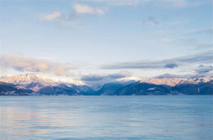 A body of water with mountains in the background