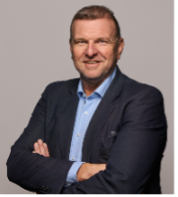 A person in a suit with his arms crossed