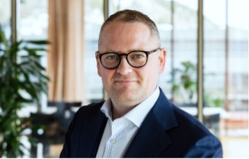 A person wearing glasses and a suit

AI-generated content may be incorrect.