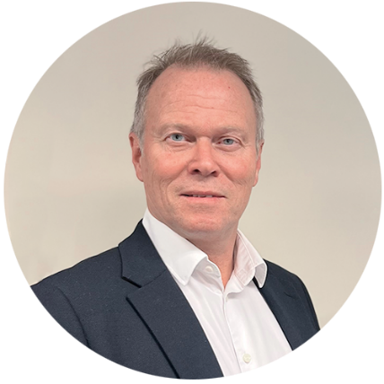 Økonomidirektør Henry Gundersen. Mann i blågrå dress med et lite smil.