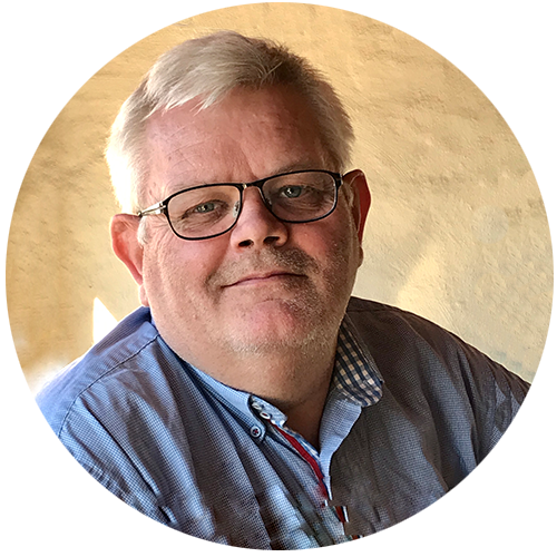 Styremedlem/ansattrepresentant Dagfinn Eriksen. Smilende mann med briller. Kledd i lys blå skjorte.

