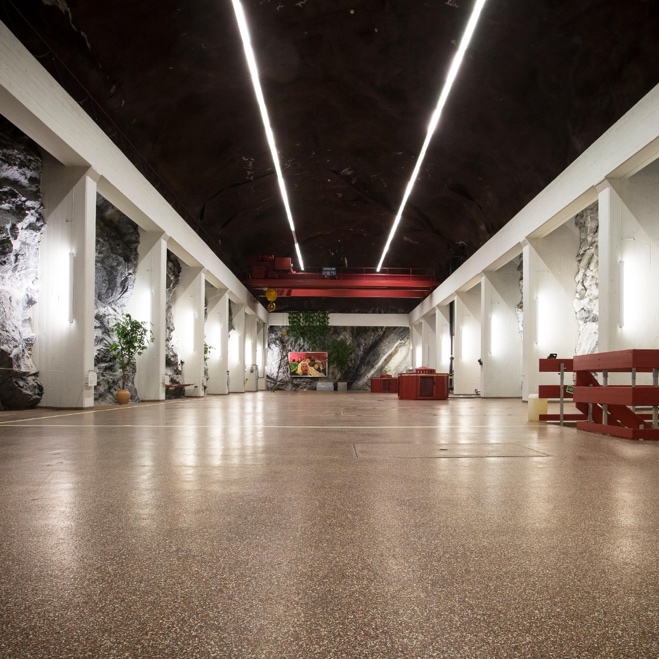 A large room with white columns and red benches

AI-generated content may be incorrect.